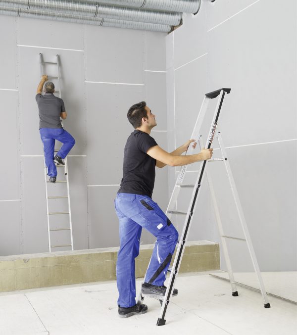 Twee professionals werken met Alu-Pro ladder en plateautrap in een industriële ruimte