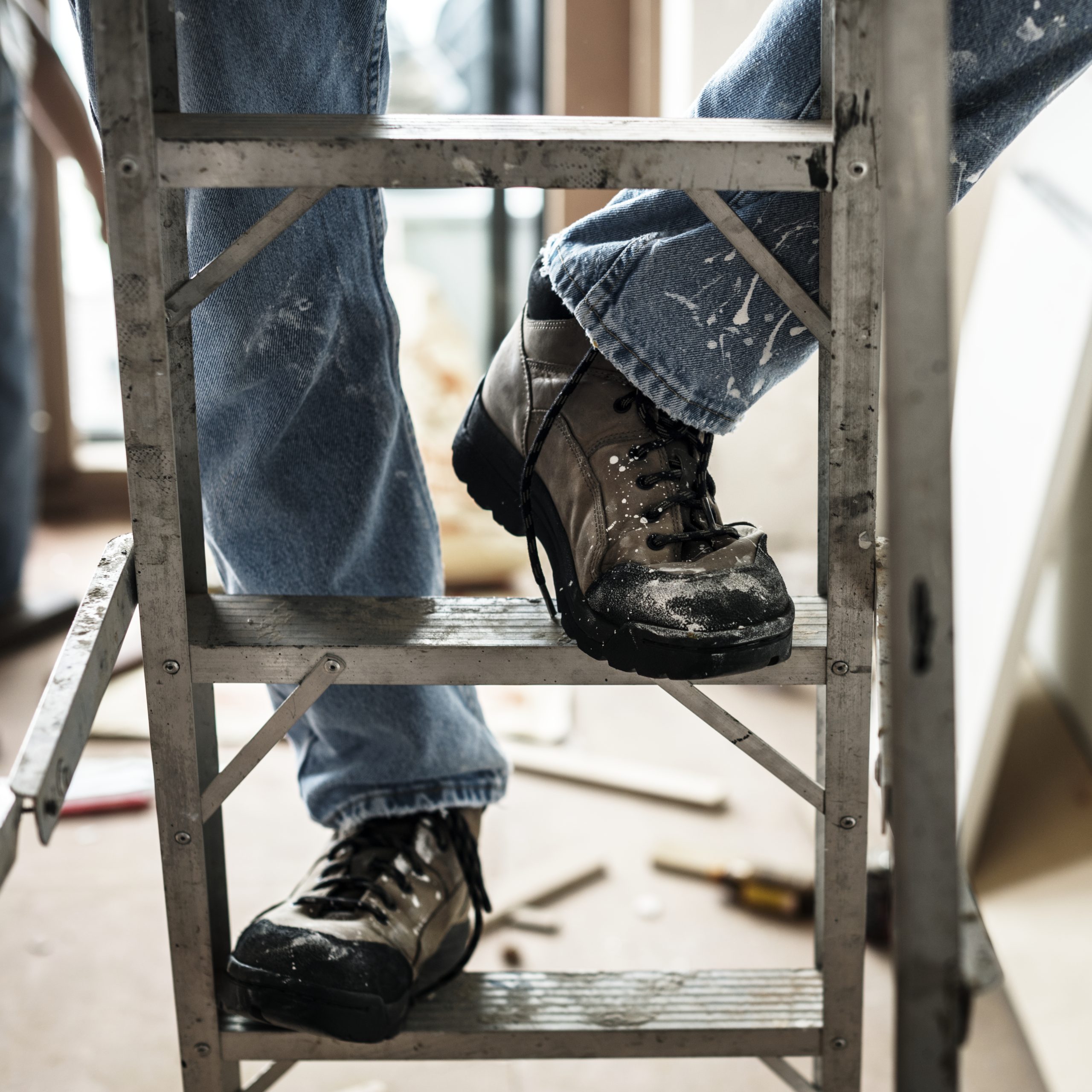 Professionele medewerker op aluminium ladder volgens veiligheidsrichtlijnen
