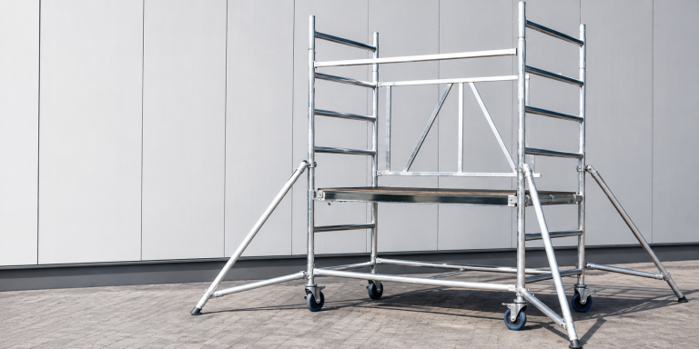 Aluminium rolsteiger met stabilisatoren klaar voor opbouw volgens de juiste veiligheidsvoorschriften.